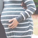 pregnant woman touching her stomach